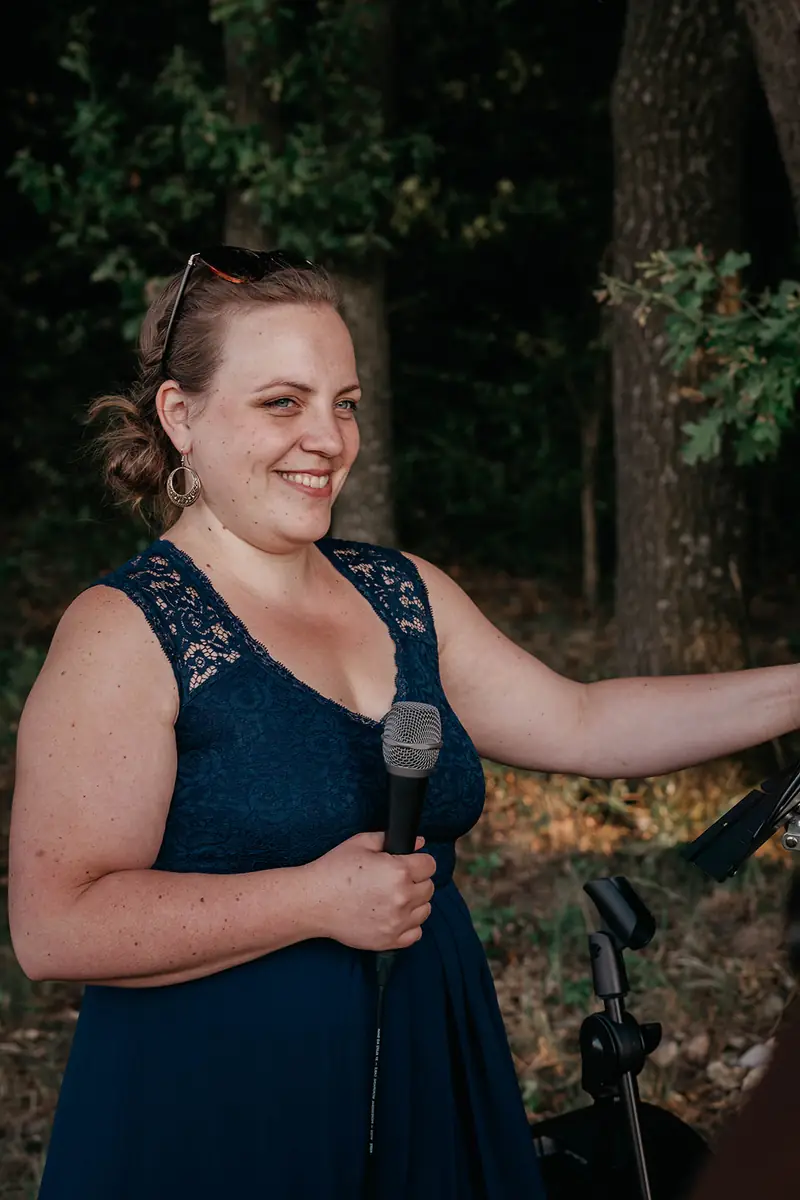 Melanie Fedl lächelt mit Mikrofon in der Hand